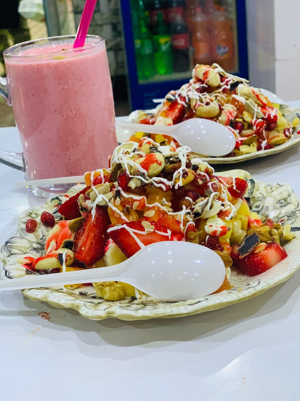 A fresh loaded fruit plate served with a strawberry shake