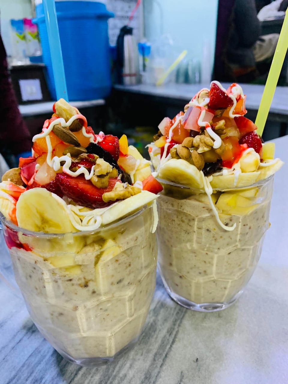 Fresh fruit cups loaded with banana, strawberry, nuts and cream