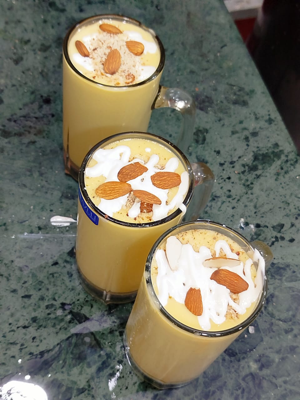 Three creamy almond shakes topped with almonds